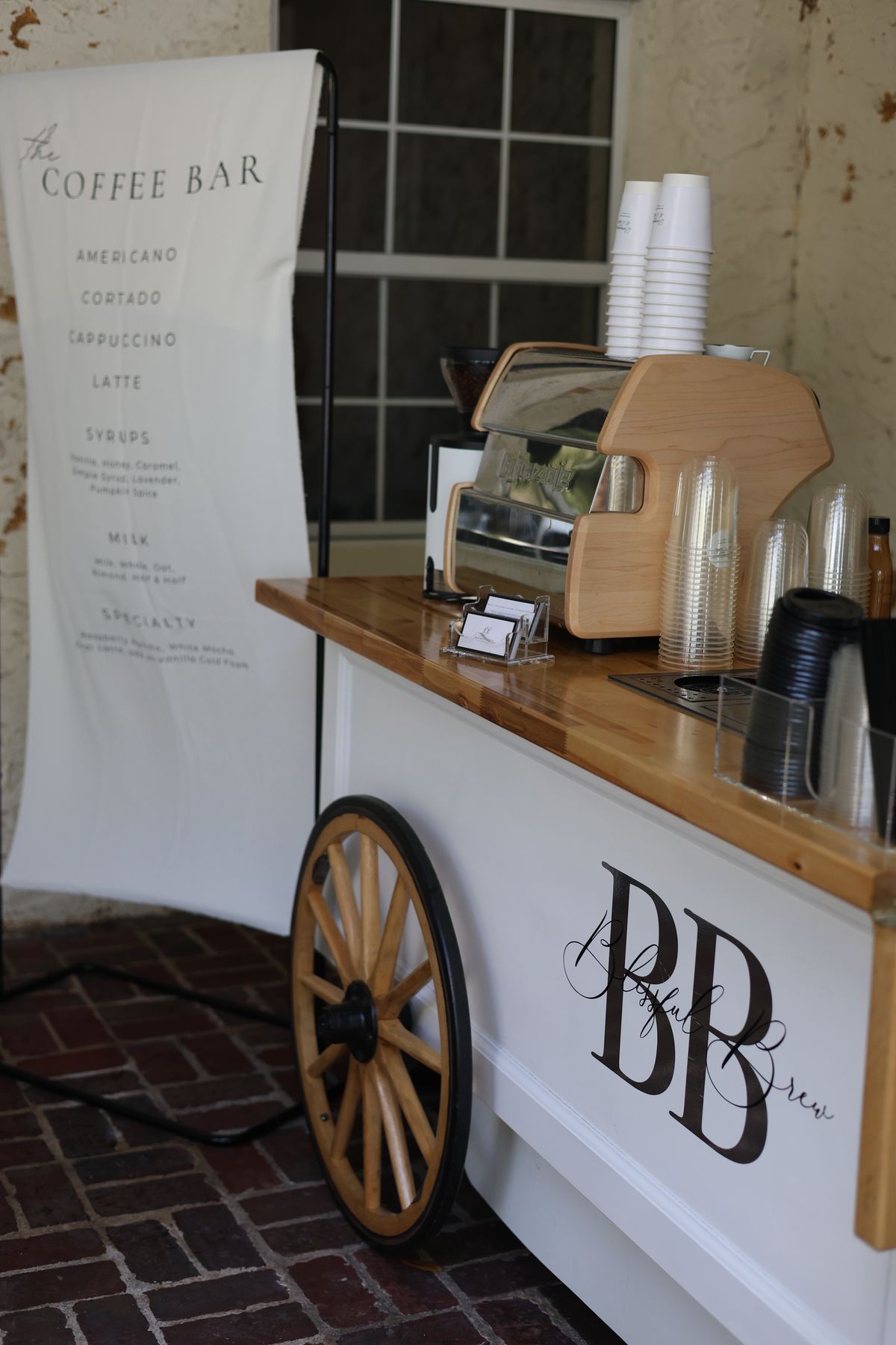 Blissful Brew coffee cart with menu banner on a brick patio